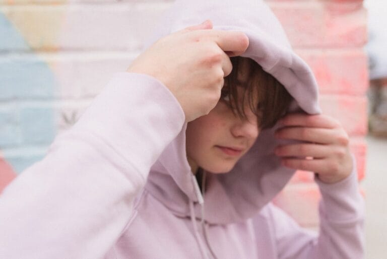 Shy teen pulls hoodie over head